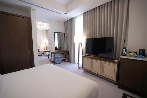a hotel room with a bed and a flat screen tv at Peninsula Worth Hotel in Al Madinah