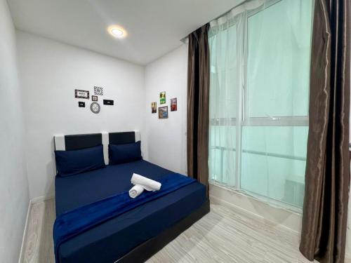 a bedroom with a blue bed with a large window at SA Sutera Avenue Homestay Opposite Imago KK in Kota Kinabalu
