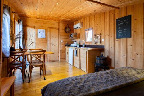Cette chambre comprend un lit, une cuisine et une table. dans l'établissement Entre Couette & Bulles, à Rivolet