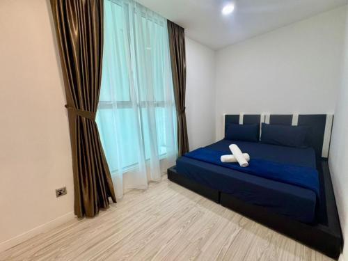 a bedroom with a blue bed and a large window at SA Sutera Avenue Homestay Opposite Imago KK in Kota Kinabalu