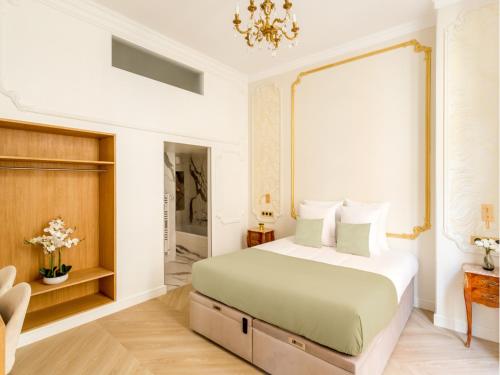 une chambre avec un grand lit et un lustre dans l'établissement Merveil - Luxury Suite - Louvre - Therese, à Paris