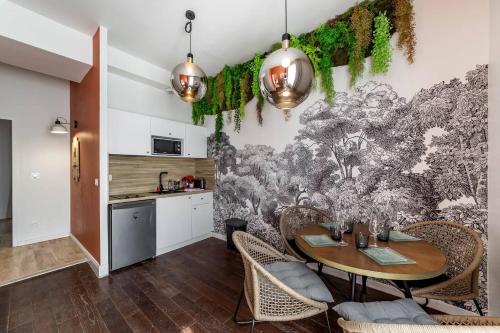 une salle à manger avec une table et une cuisine dans l'établissement La Maison d'Or, à Saint-Cyr-au-Mont-dʼOr