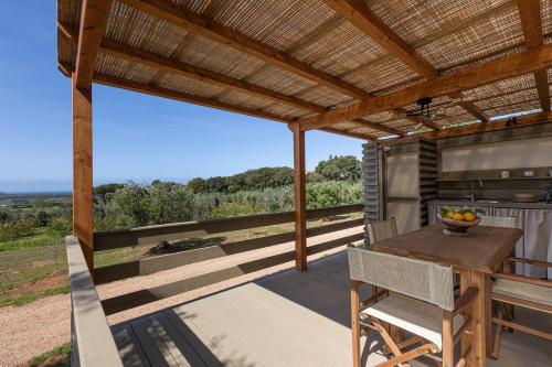 an outdoor dining area with a pergola and a table at Agriturismo Glamping L'Olivo Country Holidays in Campiglia Marittima