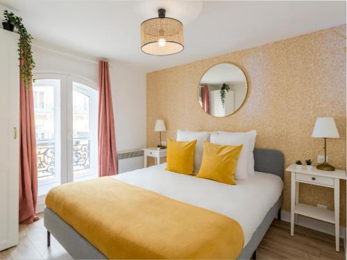 une chambre avec un grand lit avec des oreillers jaunes dans l'établissement Merveil - Family Suite - Louvre - Rivoli, à Paris