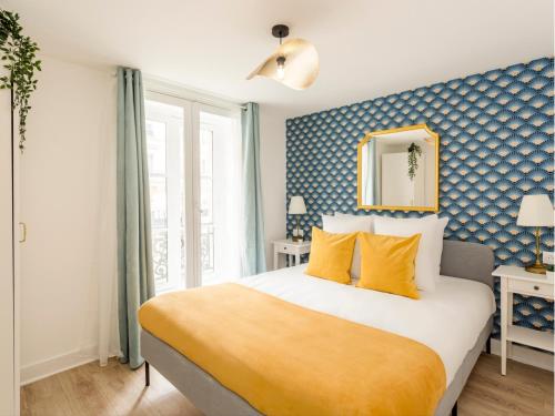 une chambre avec un grand lit avec des oreillers jaunes dans l'établissement Merveil - Family Suite - Louvre - Rivoli, à Paris