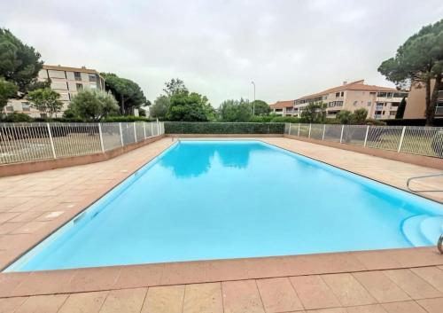 une grande piscine bleue dans un immeuble dans l'établissement Studio with pool and tennis, à Fréjus