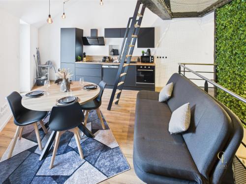 un salon avec une table et un canapé dans l'établissement L'escapade Vosgienne, à Remiremont