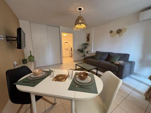 un salon avec une table et un canapé dans l'établissement Studio with pool and tennis, à Fréjus