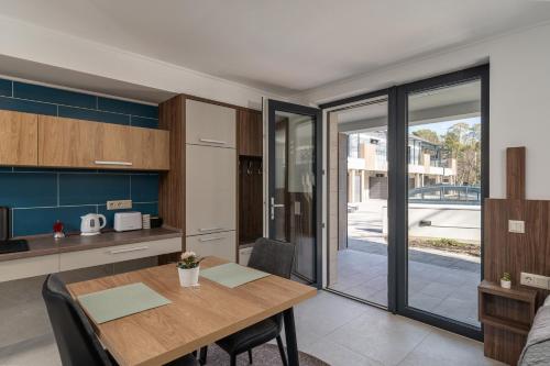 a kitchen and dining room with a wooden table at Balaton Flow Residence in Fonyód