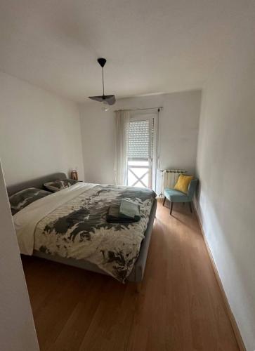 une chambre avec un lit, une chaise et une fenêtre dans l'établissement Appartement chaleureux, au calme, proche océan, à Anglet