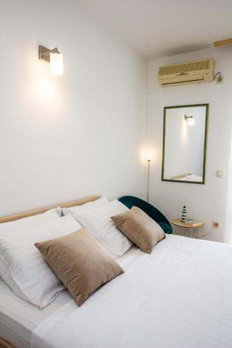 a white bed with two pillows on top of it at Apartments Ardura in Petrovac na Moru