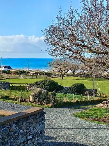 a path leading to a park with the ocean in the background at Gwyneska in Llanaber
