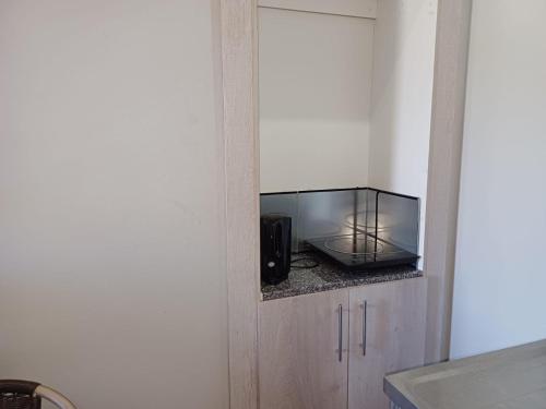 a kitchen with a microwave oven sitting on a counter at Orchard Guesthouse in Bloemfontein