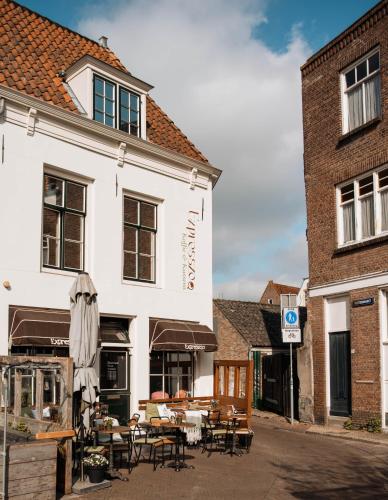 a building with tables and chairs in front of it at Koffie&kussens in Middelburg