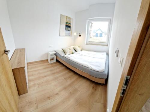 a small bedroom with a bed and a window at Domki Paula in Kudowa-Zdrój
