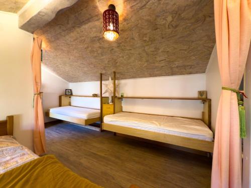 - une chambre avec deux lits et un plafond dans l'établissement Au bord de la rivière-Classé 2 étoiles, à Collobrières