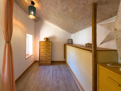 Cette chambre mansardée comprend une commode et une fenêtre. dans l'établissement Au bord de la rivière-Classé 2 étoiles, à Collobrières