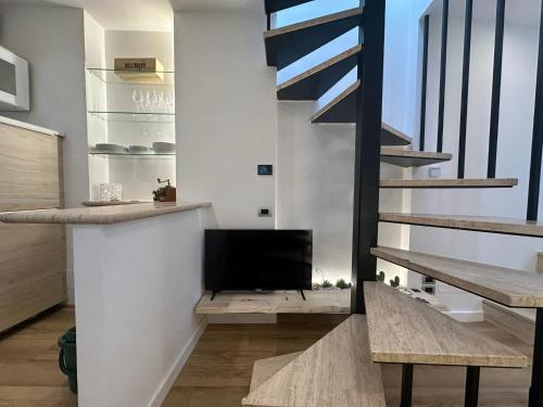 a living room with a tv and a staircase at Il nido della rondine in Ostra