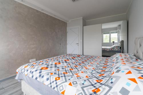a bedroom with a bed with a colorful comforter at Apartman Ivana in Novi Beograd