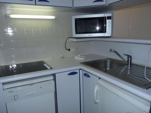 une cuisine avec un évier et un micro-ondes dans l'établissement Studio Cabine Moderne Proche Plage avec Loggia et Parking Privé - FR-1-328-112, à La Grande Motte