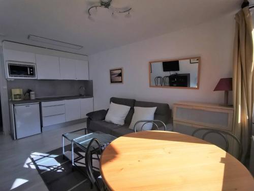 un salon avec un canapé et une table en bois dans l'établissement Studio 4 pers - balcon sud pieds des pistes - FR-1-404-4, à La Mongie