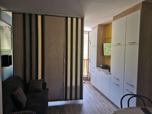 - un salon avec une porte coulissante donnant sur une cuisine dans l'établissement Charmant studio 4 pers, balcon sud face pistes, cuisine équipée, skis aux pieds - La Mongie - FR-1-404-7, à La Mongie