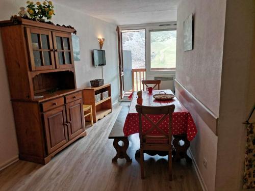un salon avec une table et un tissu de table rouge dans l'établissement Appartement 8 pers au pied des pistes, La Mongie - FR-1-404-131, à La Mongie