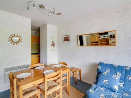 une salle à manger avec une table et un canapé bleu dans l'établissement Studio cabine 5 pers, balcon, La Mongie, proche pistes - FR-1-404-147, à La Mongie