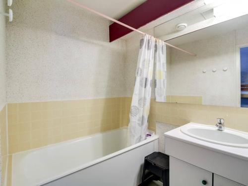 une salle de bain avec une baignoire et un lavabo dans l'établissement Studio cabine 5 pers, balcon, La Mongie, proche pistes - FR-1-404-147, à La Mongie