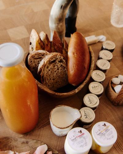 a table with a bowl of bread and a bottle of orange juice at Ne5t Hotel & Spa in Namur