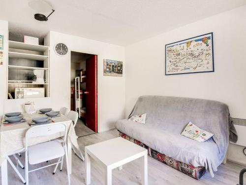 un salon avec un canapé et une table dans l'établissement Studio cabine pour 5 à La Mongie - Proche des pistes, balcon, casier à ski - FR-1-404-128, à La Mongie
