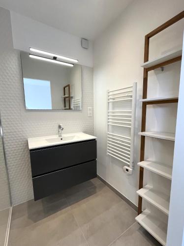 La salle de bains est pourvue d'un lavabo, d'un miroir et d'étagères. dans l'établissement Appartement avec terrasse à Santa Maria Poggio, à Santa-Maria-Poggio