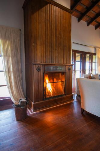 a fireplace in a living room with a fire in it at El Tránsito Hotel Boutique in Concepción