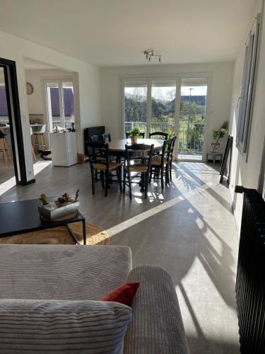 une salle à manger et un salon avec une table et des chaises dans l'établissement Maison de vacances 8 personnes, à Équevillon