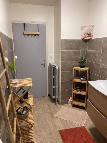 La salle de bains est pourvue d'un lavabo et d'une porte avec une étagère. dans l'établissement Maison de vacances 8 personnes, à Équevillon