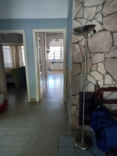 Una habitación con una pared de piedra y una lámpara de pie. en casalinda, en San Pedro