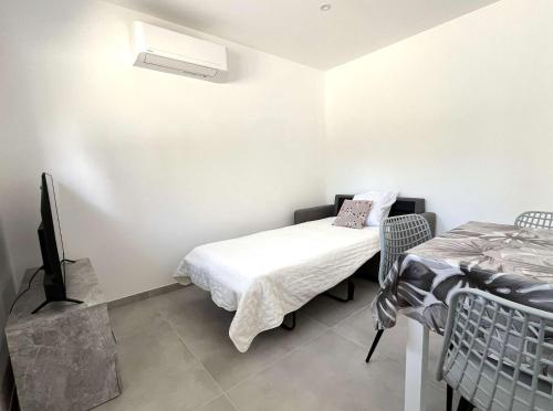 une chambre avec un lit et une télé et un lit et une télévictericter dans l'établissement Appartement avec terrasse à Santa Maria Poggio, à Santa-Maria-Poggio