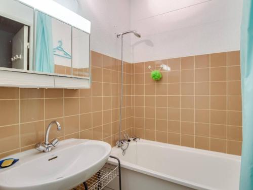 une salle de bain avec un lavabo, une baignoire et un miroir dans l'établissement Appartement 6 pers, balcon, pistes, parking couvert, centre station - FR-1-404-203, à La Mongie
