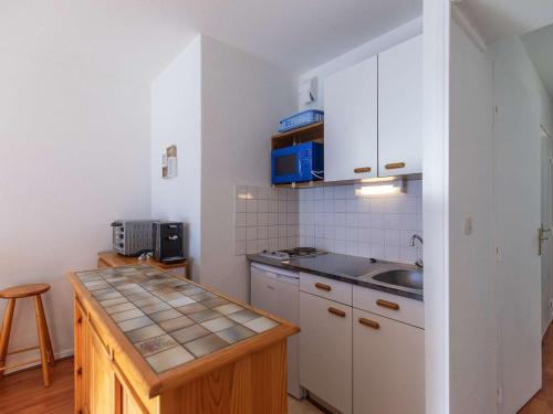 une petite cuisine avec un évier et un comptoir dans l'établissement Studio cabine 4 pers, pied des pistes avec parking couvert, balcon sud, centre station - FR-1-404-218, à La Mongie