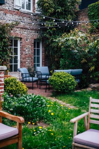 un groupe de bancs assis dans un jardin dans l'établissement Maison Grand Sable, à Veules-les-Roses