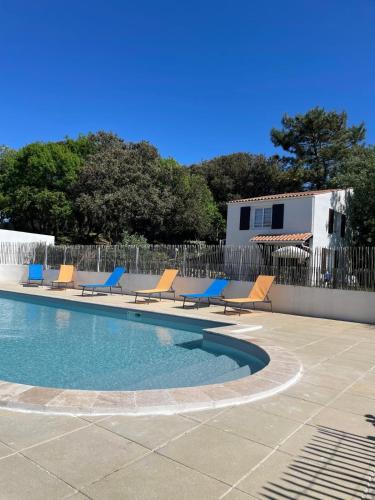 une piscine avec des chaises longues et une clôture dans l'établissement Uniek vakantiehuis aan het strand, à Saint-Pierre-dʼOléron
