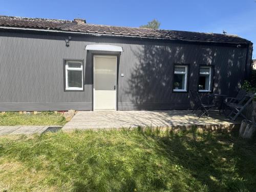 a black building with a white door and a patio at Queensferry Guest house in Rosyth