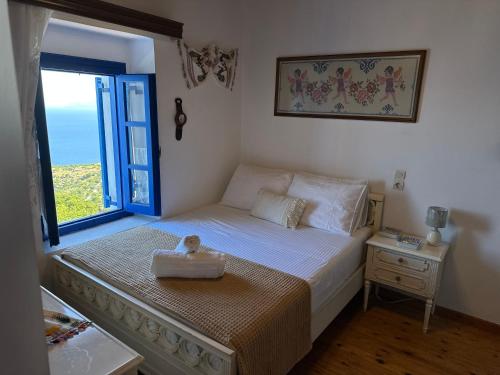 a small bedroom with a bed with a window at Emporios Traditional Sea View House in Emporeiós