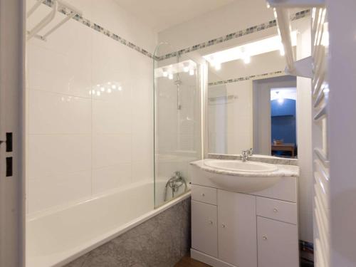 une salle de bain blanche avec un lavabo et une douche dans l'établissement Charmant T2 pour 6 avec Terrasse, Piscine Couverte et Parking à Bagnères-de-Bigorre - FR-1-404-275, à Bagnères-de-Bigorre