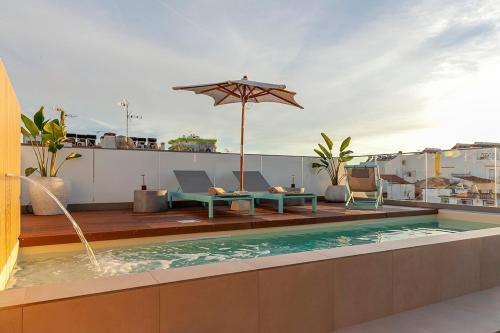 a swimming pool on a rooftop with an umbrella at Wood Beach in Monte Gordo