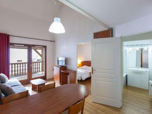 un salon avec une table et une chambre dans l'établissement Charmant Duplex 7 Pers. avec Terrasse Sud, Piscine, et Fitness à La Mongie - FR-1-404-294, à Bagnères-de-Bigorre