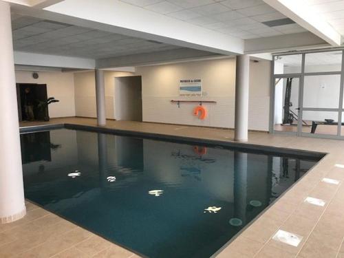 - une piscine dans une salle de sport avec un ballon d'orange dans l'eau dans l'établissement Charmant T2 avec Terrasse, Parking, Piscine Couverte et Salle de Fitness - FR-1-404-312, à Bagnères-de-Bigorre