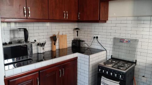 a kitchen with brown cabinets and a stove top oven at Leslie's Apartment in Nalakonge