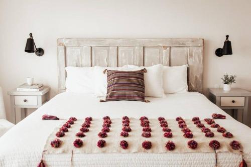 un letto con composizione floreale di Villas Ensueño - Valle De Guadalupe a San Antonio de las Minas