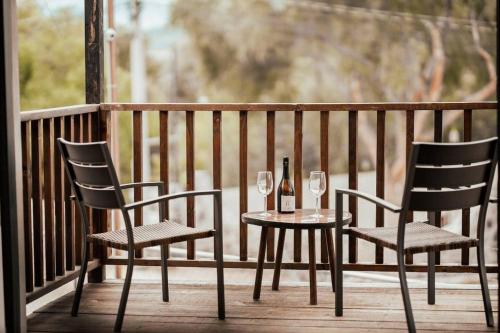 un tavolo con due sedie e una bottiglia di vino di Villas Ensueño - Valle De Guadalupe a San Antonio de las Minas
